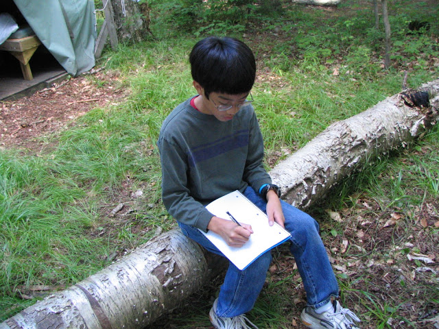 fourth grade andrew journaling on a log
