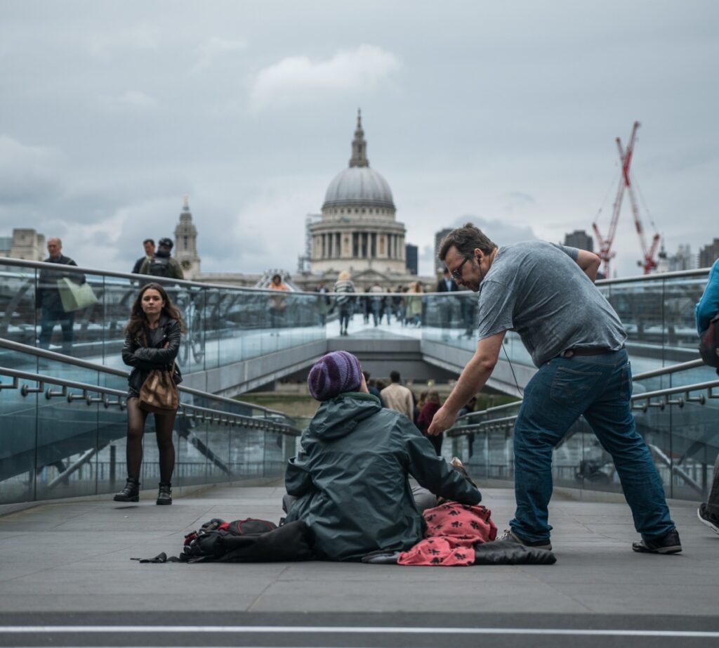 man-generously-giving-to-woman-on-ground